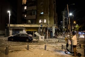 A man passes the scene where a rocket fired from Gaza strip hit a building on October 7, 2023 in Tel Aviv, Israel. Credit: Amir Levy/Getty Images.