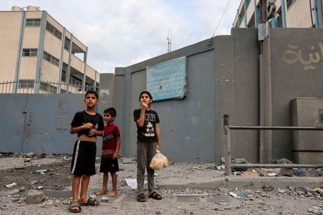 Palestinian children react to the sound of an Israeli airstrike on Gaza City on October 9, 2023