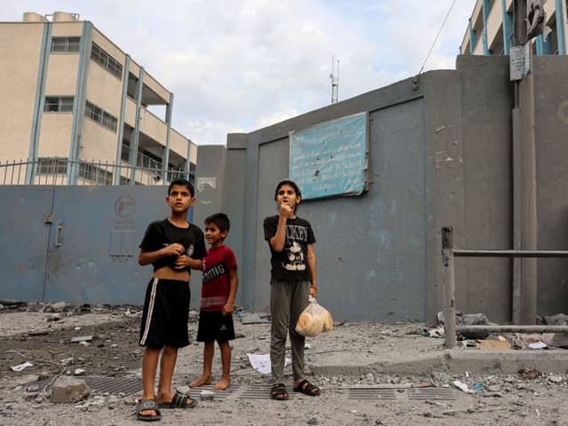  Palestinian children react to the sound of an Israeli airstrike on Gaza City on October 9, 2023