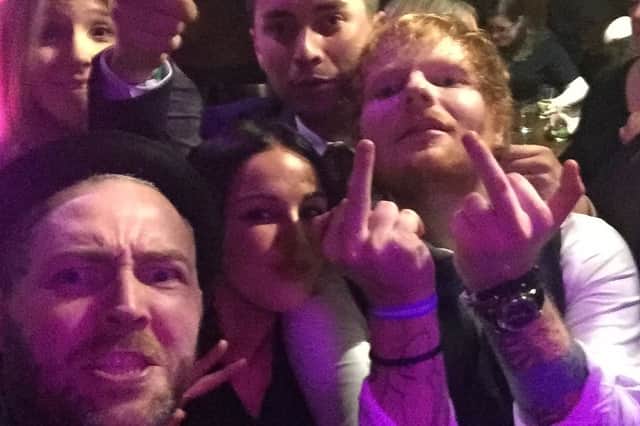 An excitable Ed Sheeran with tattoo artist Kevin Paul and others. (Photo by Kevin Paul/SWNS)