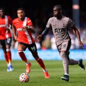 Yves Bissouma of Tottenham Hotspur runs with the ball whilst under pressure from Jacob Brown of Luton Town . (Photo by Marc Atkins/Getty Images)