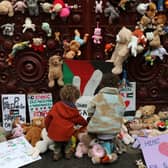 Young children bring teddy bears and other soft toys representing children killed in Gaza, to the gates of the Foreign, Commonwealth and Development Office