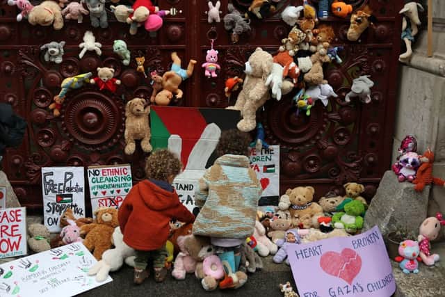 Young children bring teddy bears and other soft toys representing children killed in Gaza, to the gates of the Foreign, Commonwealth and Development Office