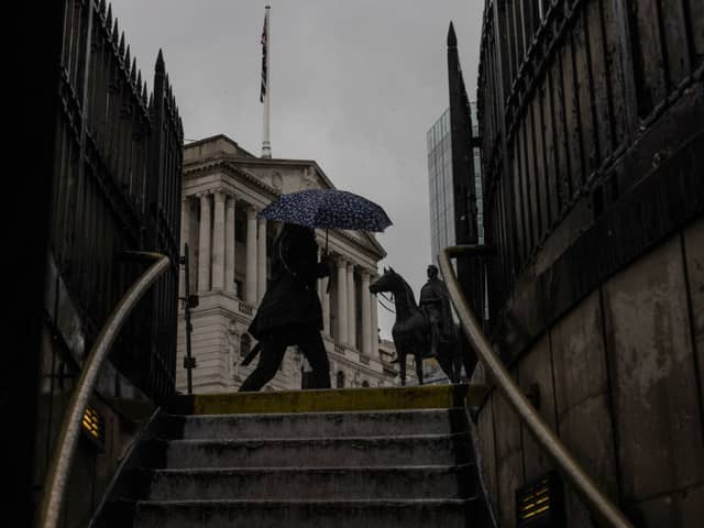A member of the public walks through heavy rain near the Bank of England in May 2023. (Photo by Dan Kitwood/Getty Images)