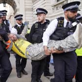 Met Police officers remove a Just Stop Oil protester detained whilse blocking Whitehall during a protest (Photo: Lucy North/PA Wire)