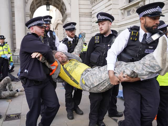 Met Police officers remove a Just Stop Oil protester detained whilse blocking Whitehall during a protest (Photo: Lucy North/PA Wire)