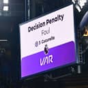The big screen displays the outcome of a VAR (Video Assistant Referee) review into a foul by Chelsea's Spanish defender #03 Marc Cucurella 