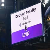 The big screen displays the outcome of a VAR (Video Assistant Referee) review into a foul by Chelsea's Spanish defender #03 Marc Cucurella 