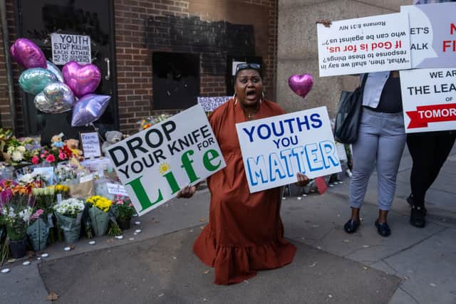 A woman protests against youth violence at the scene of Elianne Andam's murder in Croydon.