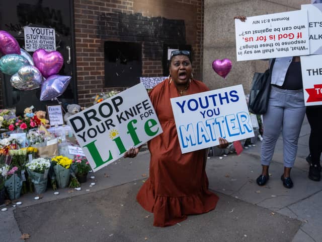 A woman protests against youth violence at the scene of Elianne Andam's murder in Croydon.