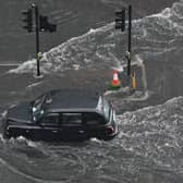  A London taxi drives through water on a flooded road in The Nine Elms district of London on July 25, 2021 during heavy rain. 