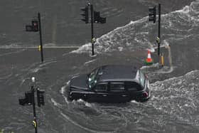  A London taxi drives through water on a flooded road in The Nine Elms district of London on July 25, 2021 during heavy rain. 