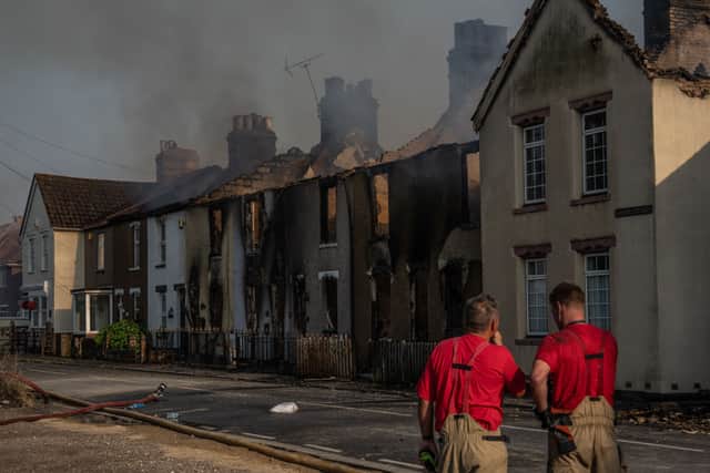 Fireman work next to buildings destroyed by fire on July 19, 2022 in Wennington, England. A series of grass fires broke out around the British capital amid an intense heatwave. 