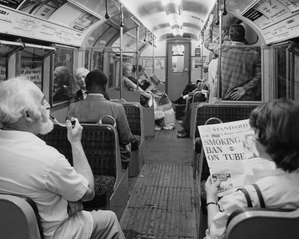 A man smoking a pipe while travelling on a London Underground Nothern Line train as a woman in the seat next to him reads a Evening Standard newspaper with title that reads 'Smoking Ban on Tube', London, UK, 21st June 1984. (Photo by D. Jones/Daily Express/Hulton Archive/Getty Images)