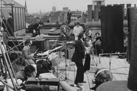 The Beatles performing their last live public concert on the rooftop of the Apple Corps building for director Michael Lindsey-Hogg's film documentary, Let It Be, in Savile Row, London, on January 30, 1969. Ringo Starr drums while Paul McCartney, John Lennon and George Harrison form the front line. Lennon's wife, Yoko Ono, sits on the right.