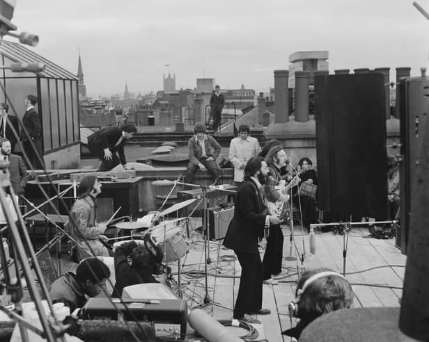 The Beatles performing their last live public concert on the rooftop of the Apple Corps building for director Michael Lindsey-Hogg's film documentary, Let It Be, in Savile Row, London, on January 30, 1969. Ringo Starr drums while Paul McCartney, John Lennon and George Harrison form the front line. Lennon's wife, Yoko Ono, sits on the right.