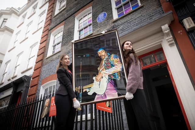 Olwen Foulkes (left) and Jennifer Newbery carry a vintage poster of Jimi Hendrix, one of three acquired from the Freddie Mercury estate sale, into Handel Hendrix House in Mayfair, London.