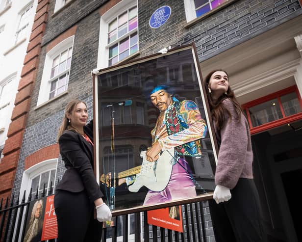 Olwen Foulkes (left) and Jennifer Newbery carry a vintage poster of Jimi Hendrix, one of three acquired from the Freddie Mercury estate sale, into Handel Hendrix House in Mayfair, London.