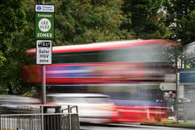 Vehicles pass by a sign indicating the new boundary of the ULEZ. 