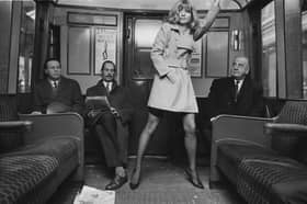 Swedish-German model model Uschi Bernell wearing a short coat on an underground train, London, UK, 20th December 1968. 