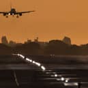 A passenger aircraft prepares to land during sunrise at London Heathrow Airport. 