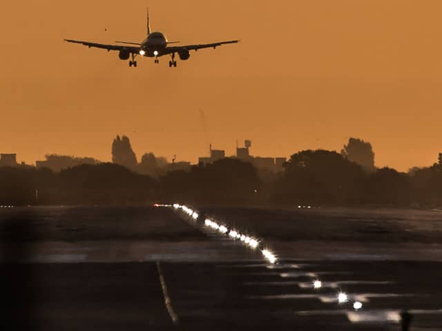 A passenger aircraft prepares to land during sunrise at London Heathrow Airport. 