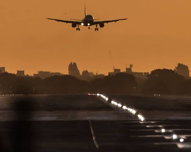 A passenger aircraft prepares to land during sunrise at London Heathrow Airport. 