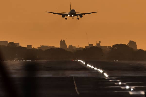 A passenger aircraft prepares to land during sunrise at London Heathrow Airport. 