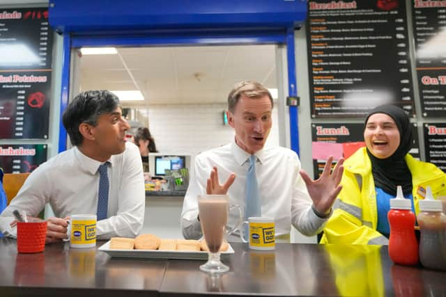 Prime Minister Rishi Sunak and UK Chancellor Jeremy Hunt have a drink and biscuits as they speak with employees during a visit to a London warehouse on March 6. 