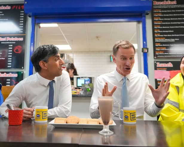 Prime Minister Rishi Sunak and UK Chancellor Jeremy Hunt have a drink and biscuits as they speak with employees during a visit to a London warehouse on March 6. 