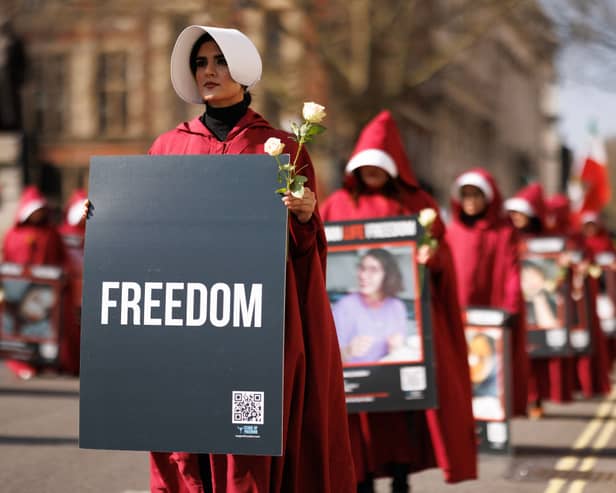 Protesters dressed as handmaids from The Handmaid's Tale march from Parliament Square to Iran's embassy to highlight repression of women in that country on March 8, 2024 in London, England. 