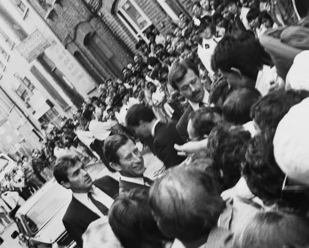 Prince Charles meeting the public in Brick Lane in 1987 while bodyguards look on and police hold back crowds.
