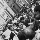 Prince Charles meeting the public in Brick Lane in 1987 while bodyguards look on and police hold back crowds.