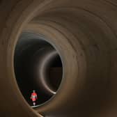 A civil engineer walks inside a 7 metre concrete tunnel at the Thames Tideway building site, in west London.