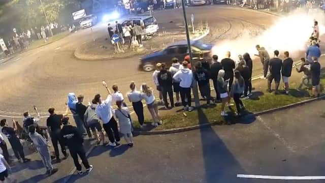 Driver does doughnuts at illegal car meet.