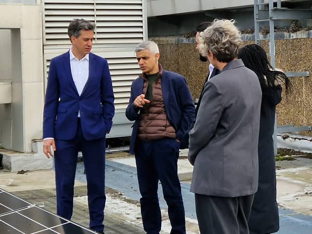 Ed Miliband and Sadiq Khan examine solar panels on a roof of a school in Stoke Newington