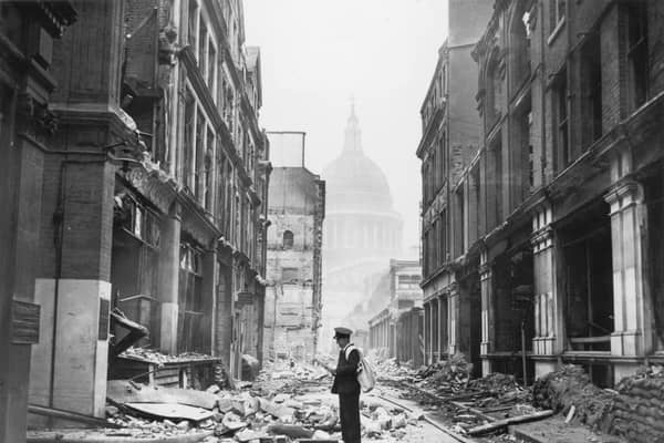 A postman tries to deliver letters to premises in Watling Street in the City of London, after a night time German air raid, London, May 1941. The dome of St Paul's Cathedral is in the background. (Photo by Central Press/Hulton Archive/Getty Images)