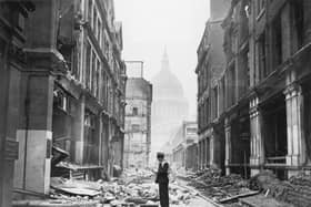 A postman tries to deliver letters to premises in Watling Street in the City of London, after a night time German air raid, London, May 1941. The dome of St Paul's Cathedral is in the background. (Photo by Central Press/Hulton Archive/Getty Images)