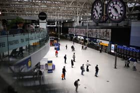 Commuters look at the departures board at Waterloo train in September 2023.