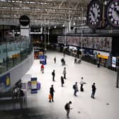 Commuters look at the departures board at Waterloo train in September 2023.