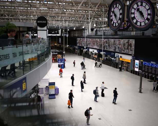 Commuters look at the departures board at Waterloo train in September 2023.