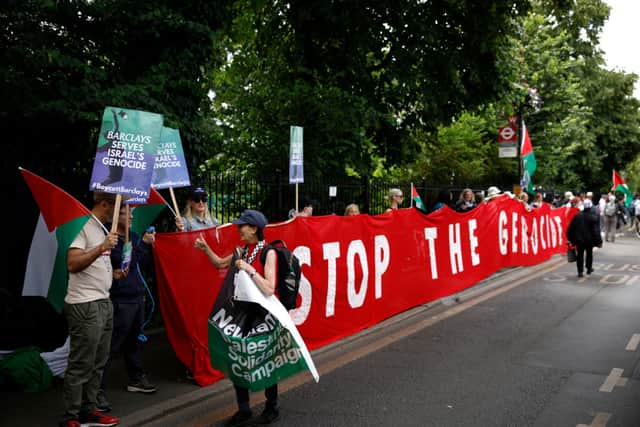  Protesters hold up signs and a banner reading 'Stop The Genocide' in protest against Barclays Bank