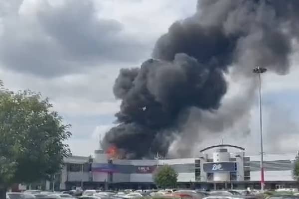 Flames rage through factory as plumes of smoke rise into air.