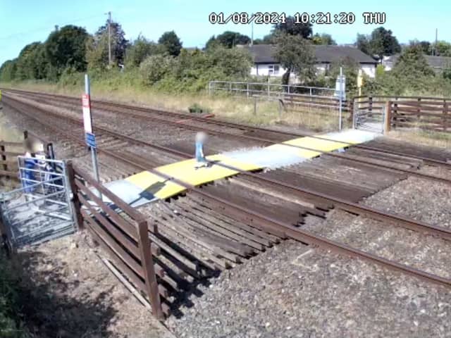 Toddler steps onto Sandy Lane level crossing in Prestatyn, North Wales.