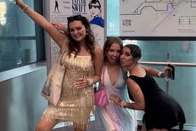 Fans attending Taylor Swift's The Eras Tour pose in front of TfL's Swift-themed Tube map at Wembley Park Tube station