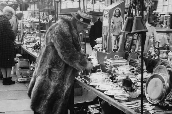 A character browsing the stalls at Portobello Road market, London in 1966
