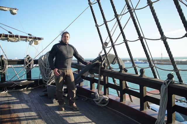Claudio Lozano stands on the deck of a Puntales ship, standing by the mast. The ship was used to defend against the french navy in the penninsular war in Spain
