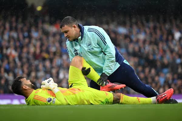 David Raya receives treatment against Manchester City.