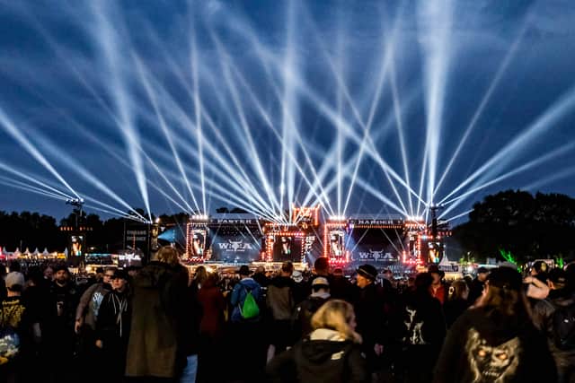 Festival-goers cheer during a concert after the opening of the "infield" in front of the main stages at the Wacken Open Air music festival on August 2, 2023 in Wacken, northern Germany.