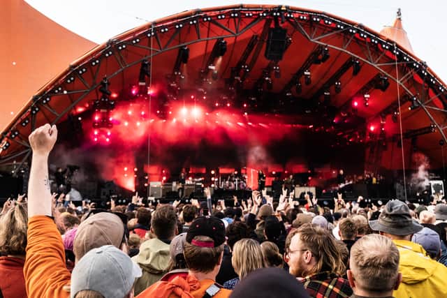 Spectators cheer as they attend a concert of US rock band Foo Fighters performing on the Orange Stage at Roskilde Festival on July 5, 2024 in Roskilde, Denmark.
